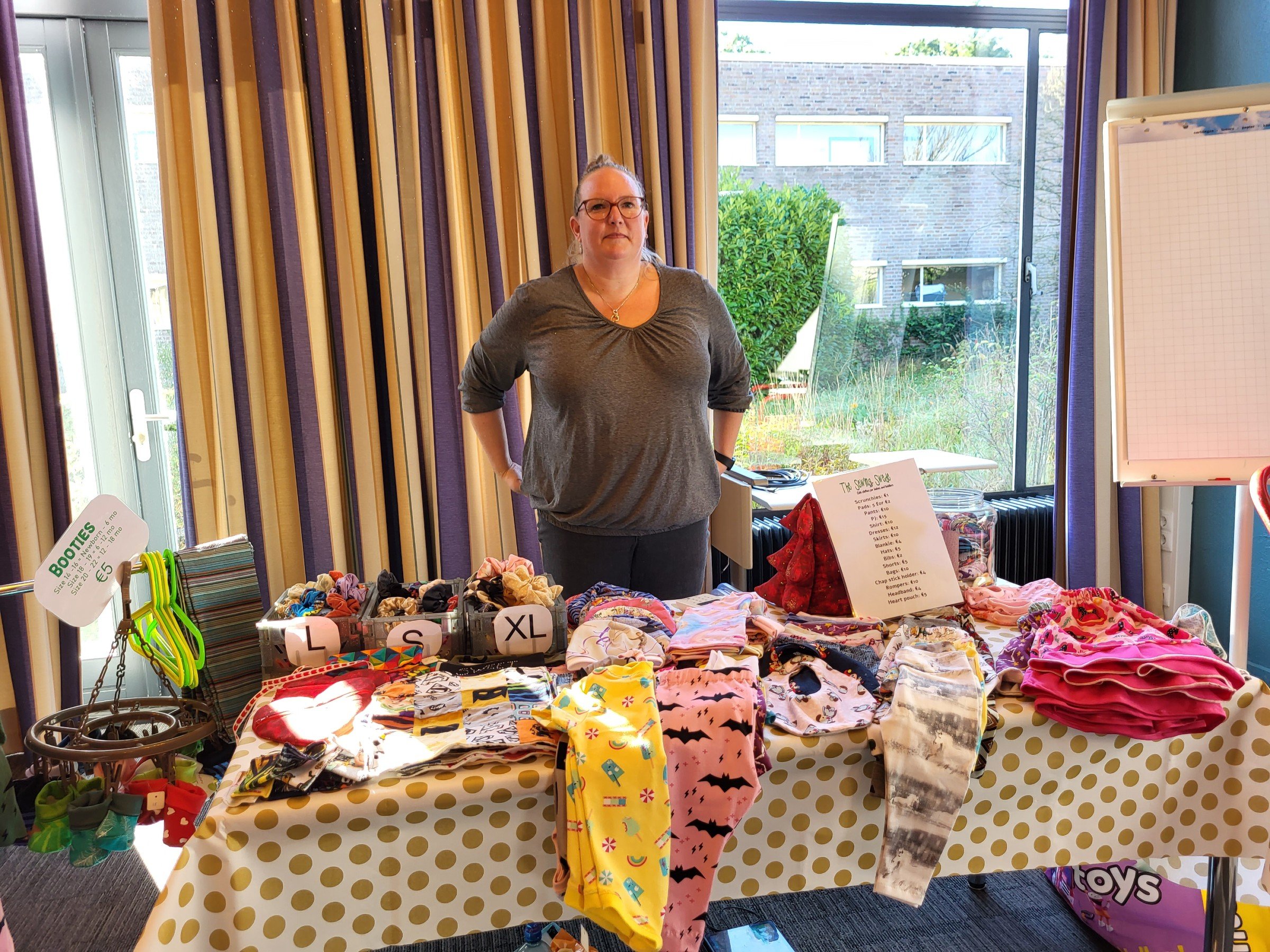 Me with a table full of handmade clothes