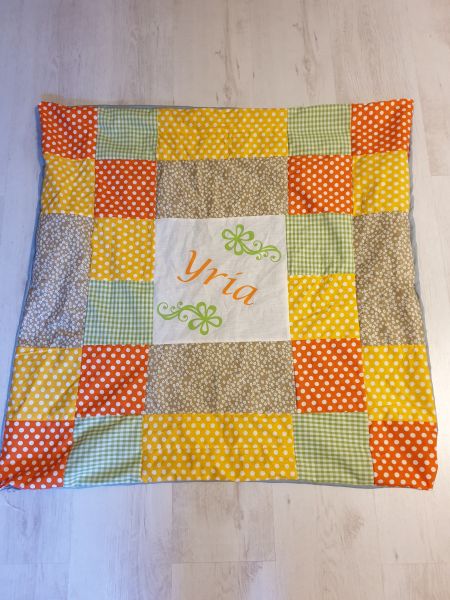 A patchwork blanket with pressed on name