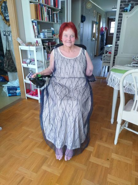 Woman in wheelchair with dress on. Taupe bottom and a second fabric of mesh